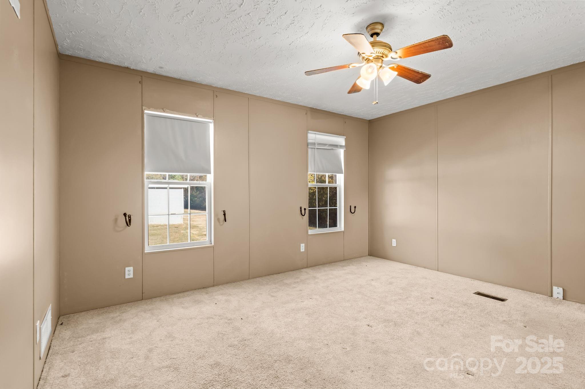 1060 Beckham Road Salisbury, NC 28147 - Photo 17 of 28 an empty room with windows and ceiling fan