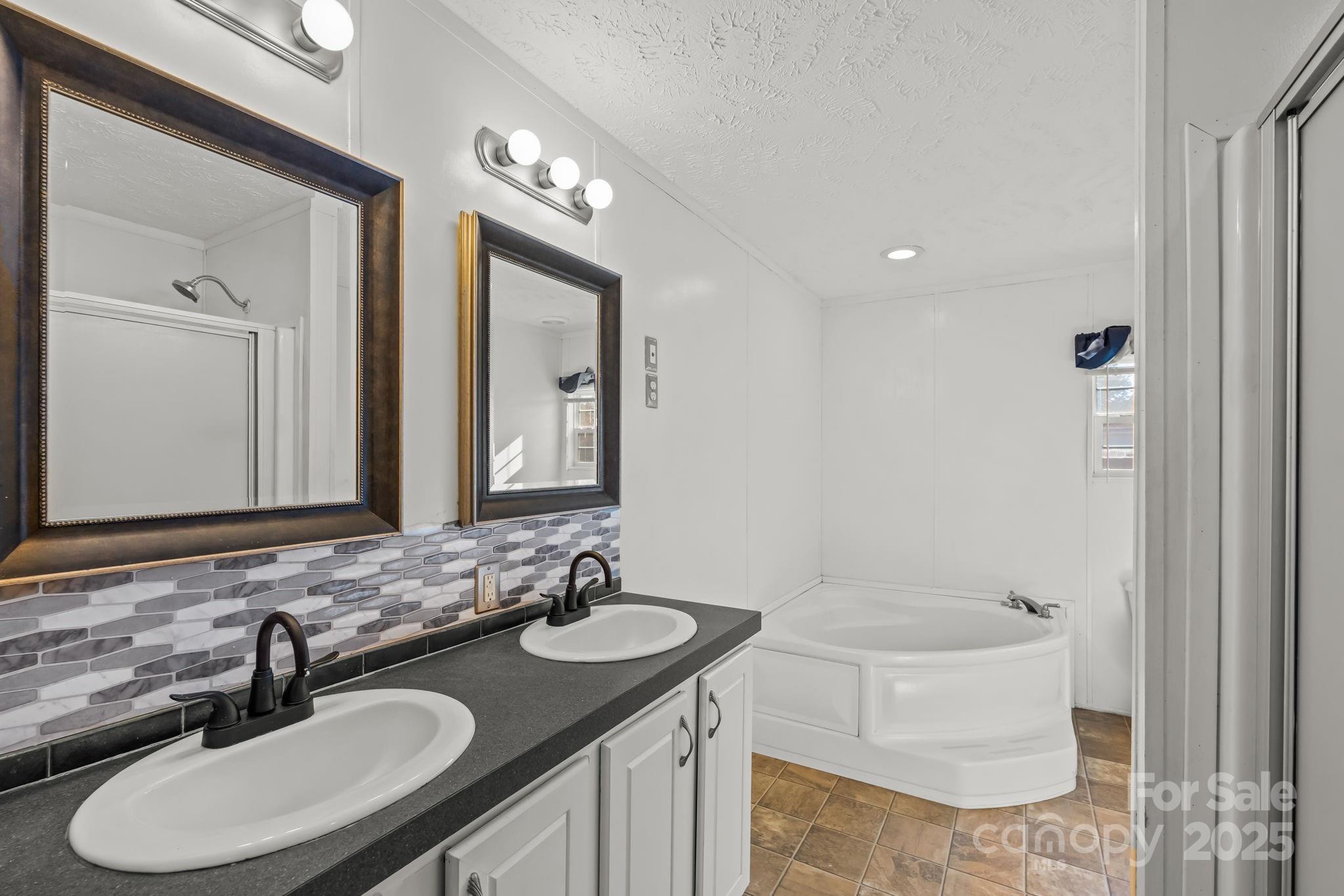 1060 Beckham Road Salisbury, NC 28147 - Photo 19 of 28 a bathroom with a sink double vanity granite tub and a mirror