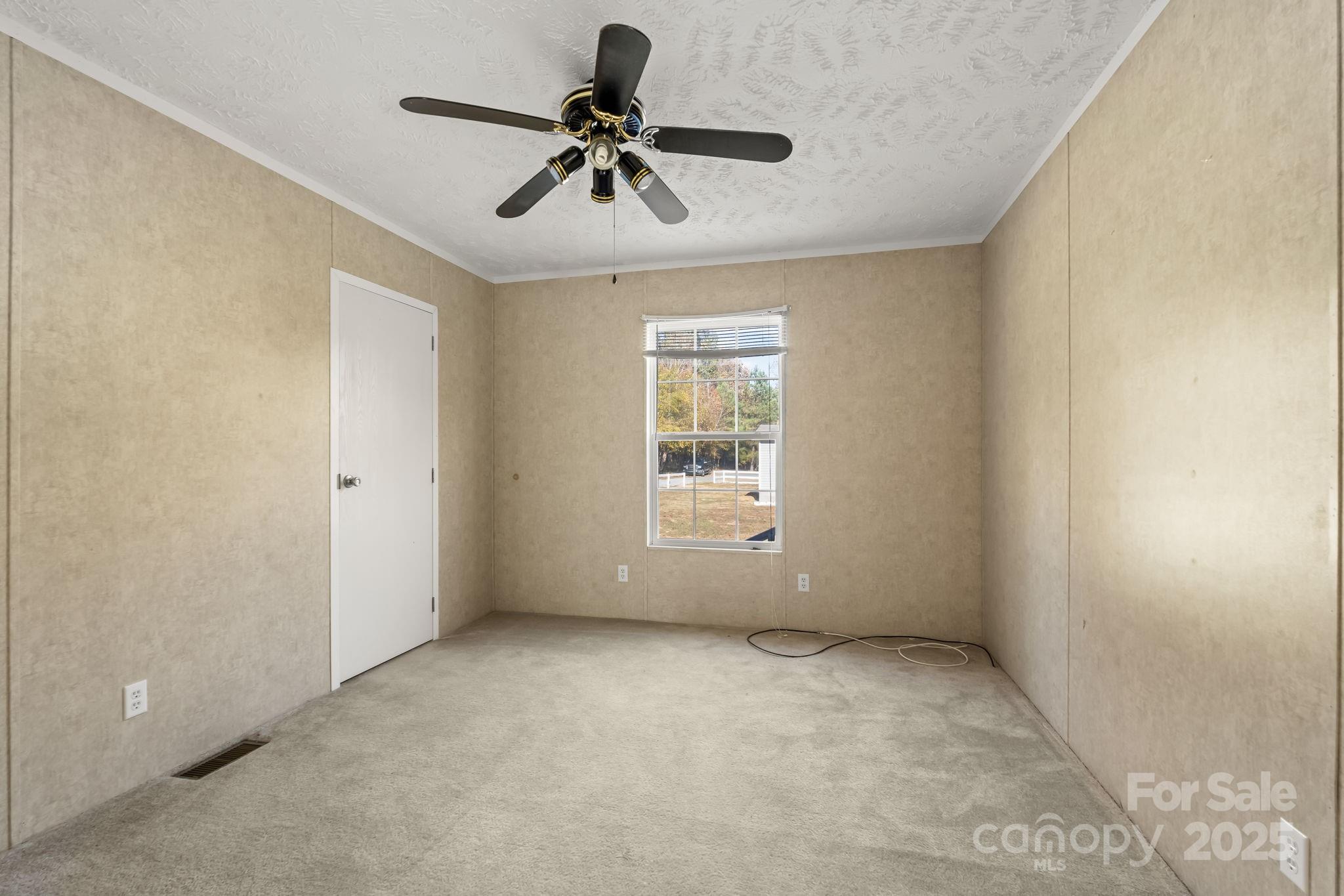 1060 Beckham Road Salisbury, NC 28147 - Photo 25 of 28 an empty room with a ceiling fan and windows