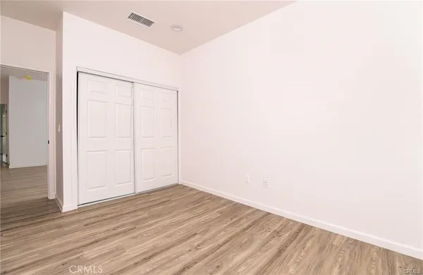 an empty room with wooden floor and white walls