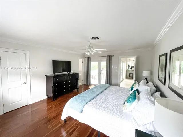 a spacious bedroom with a bed and a flat screen tv