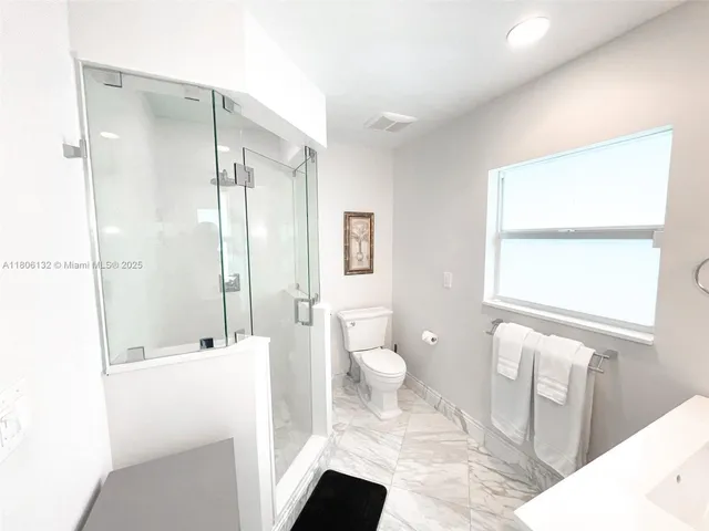 a bathroom with a sink a toilet and a shower