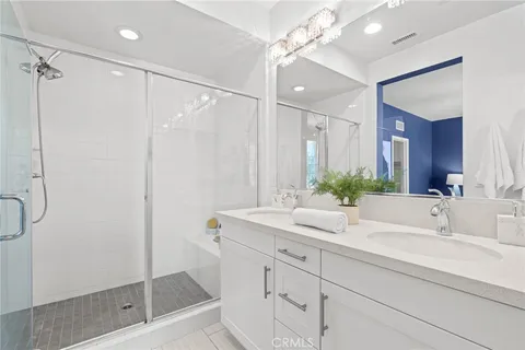 a bathroom with a shower sink vanity granite and mirror