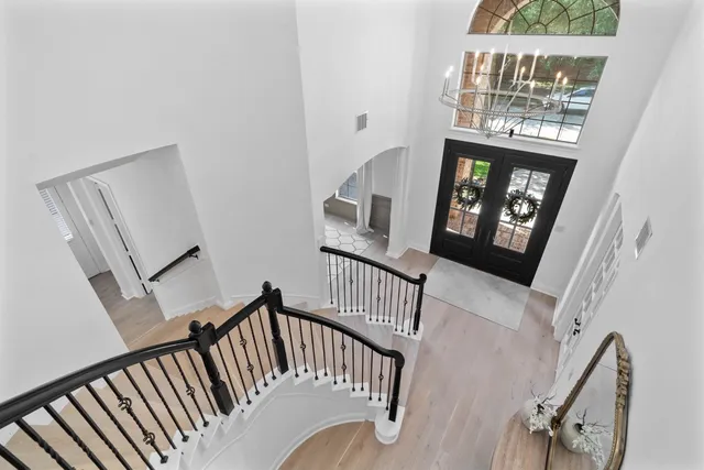a spacious bedroom with a bed and a chandelier