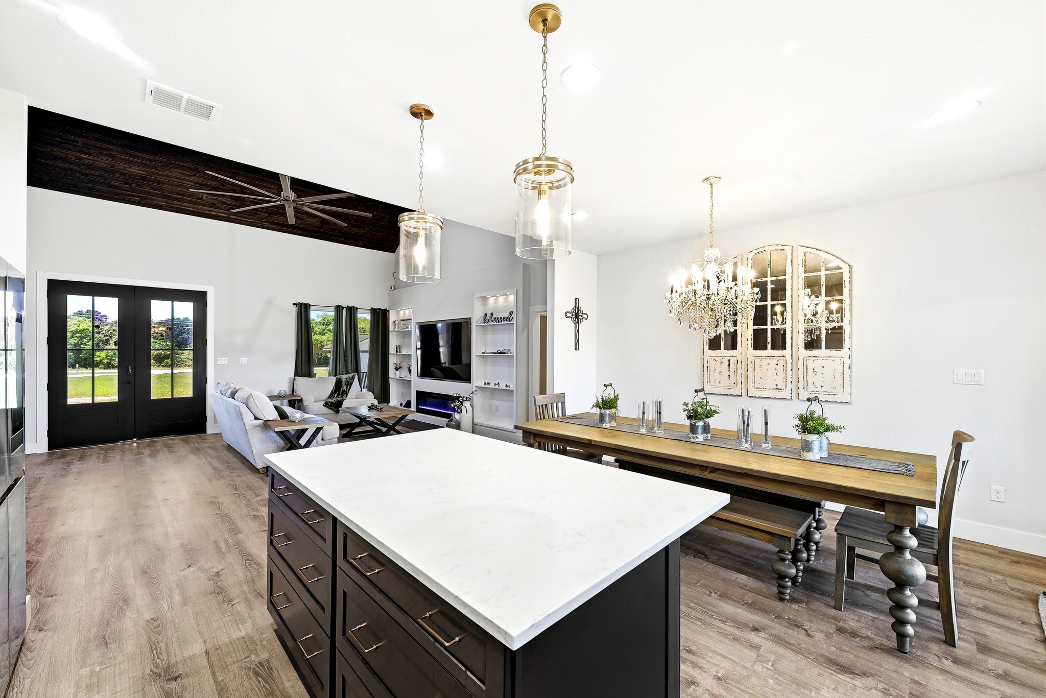 2889 Old McMahan Road Lockhart, TX 78644 - Photo 14 of 33 An open-concept interior unites living and dining areas, featuring a spacious kitchen island and elegant wood flooring.