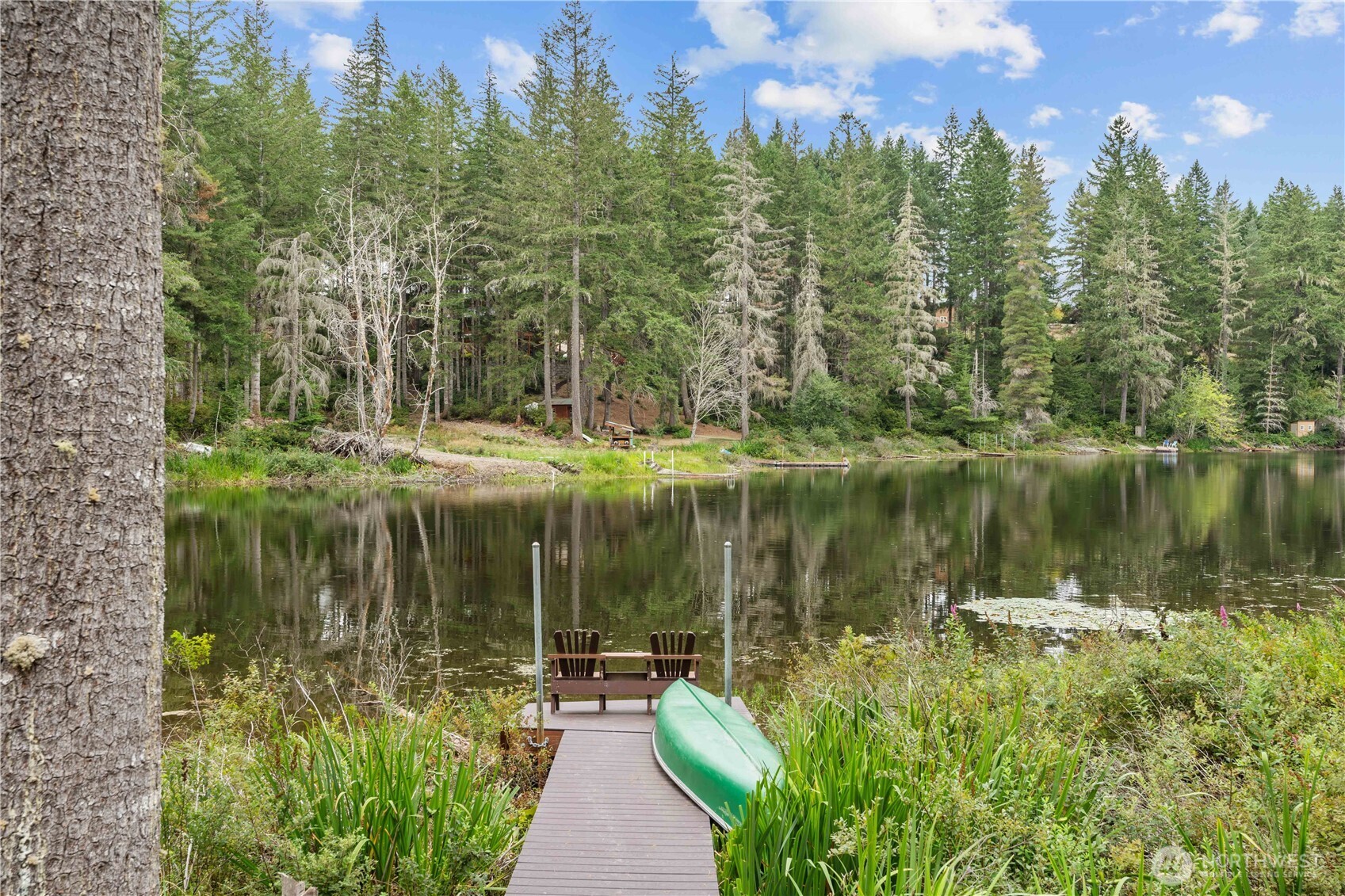 7131 Northeast Tahuya Blacksmith Road Belfair, WA 98528 - Photo 1 of 33 a view of a lake with a house in the background