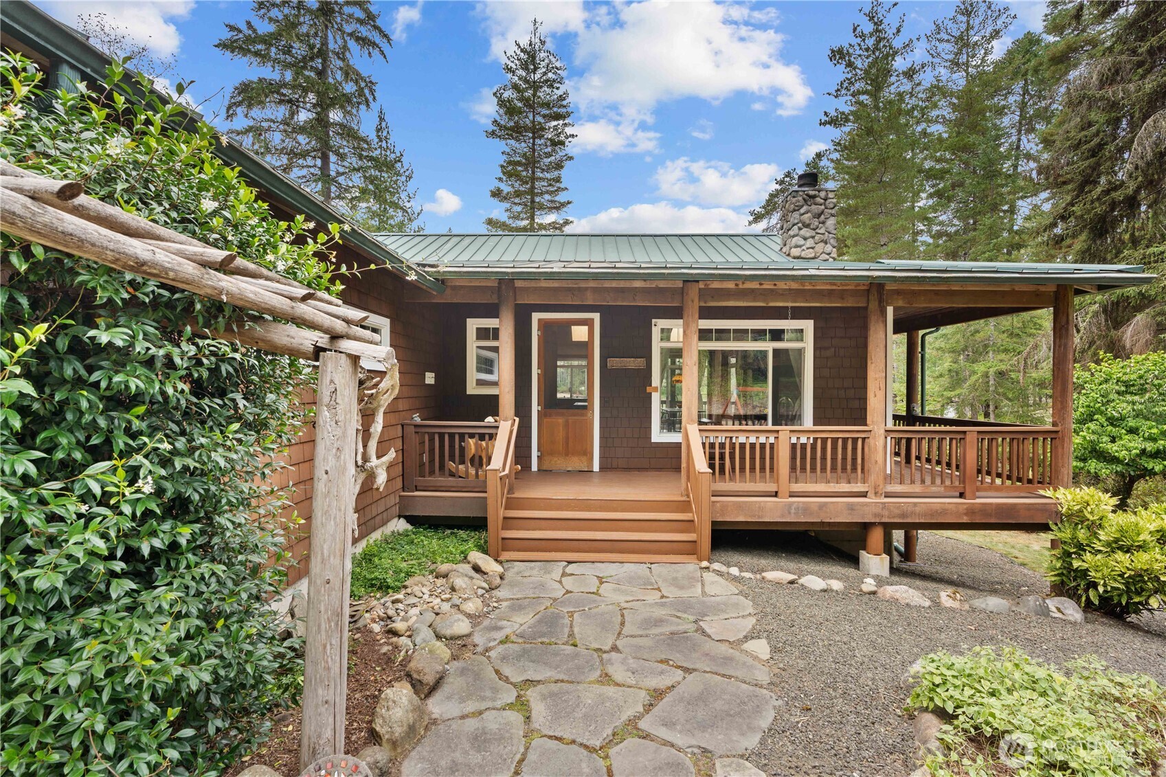 7131 Northeast Tahuya Blacksmith Road Belfair, WA 98528 - Photo 2 of 33 a front view of a house with a garden