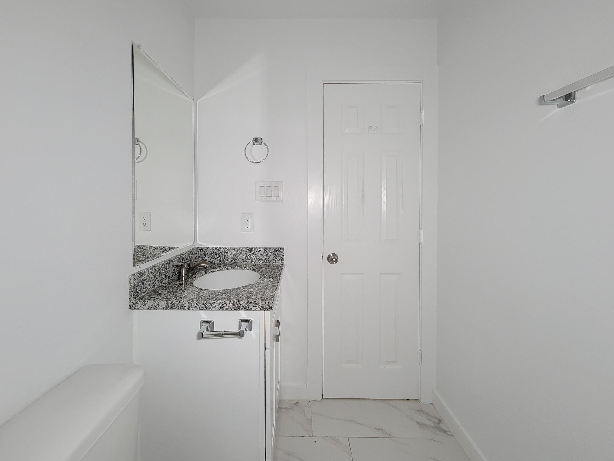 8122 Sterlingshire Street, Unit B Houston, TX 77078 - Photo 23 of 27 a bathroom with a granite countertop sink and mirror