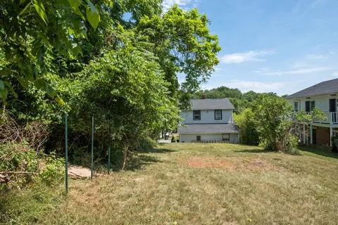 a view of a house with a tree in the yard