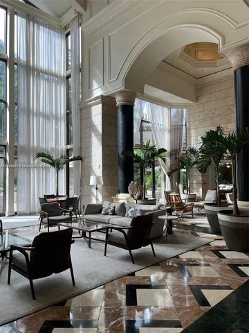 a living room with fireplace furniture and floor to ceiling windows