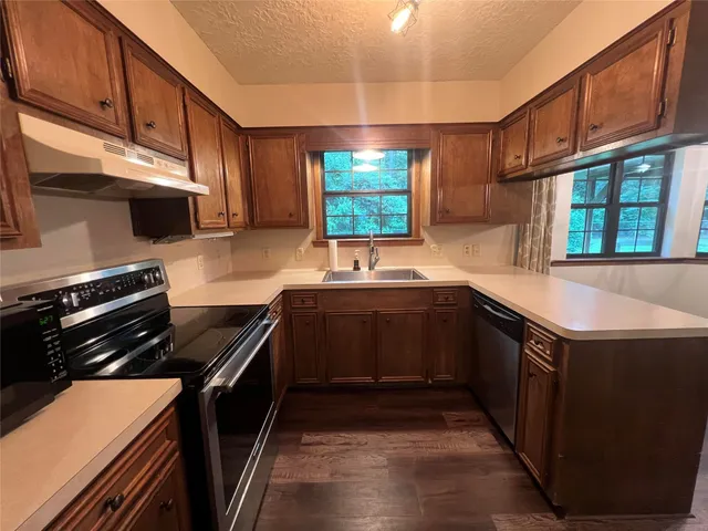 a kitchen with stainless steel appliances a sink stove and cabinets