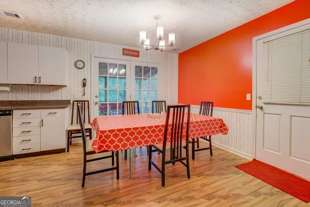 a dining room with furniture a chandelier and wooden floor