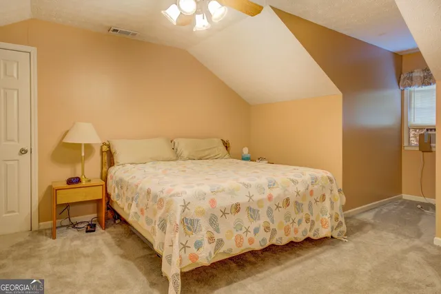 a large bed sitting in a bedroom next to a lamp