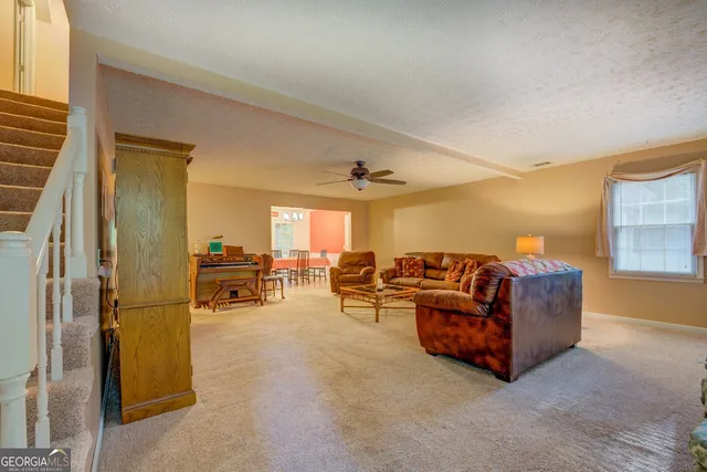 a living room with furniture and a dining table with projector