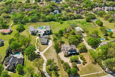 an aerial view of a house with a yard and lake view