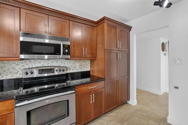 a kitchen with a refrigerator sink and cabinets