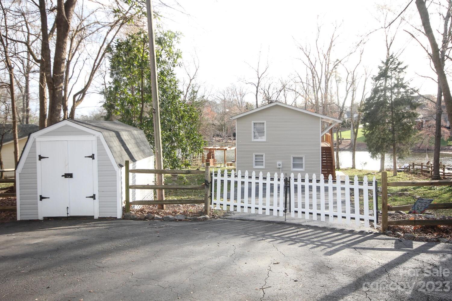 5615 Cypress Road Clover, SC 29710 - Photo 22 of 26 a view of a white house with a large trees and wooden fence