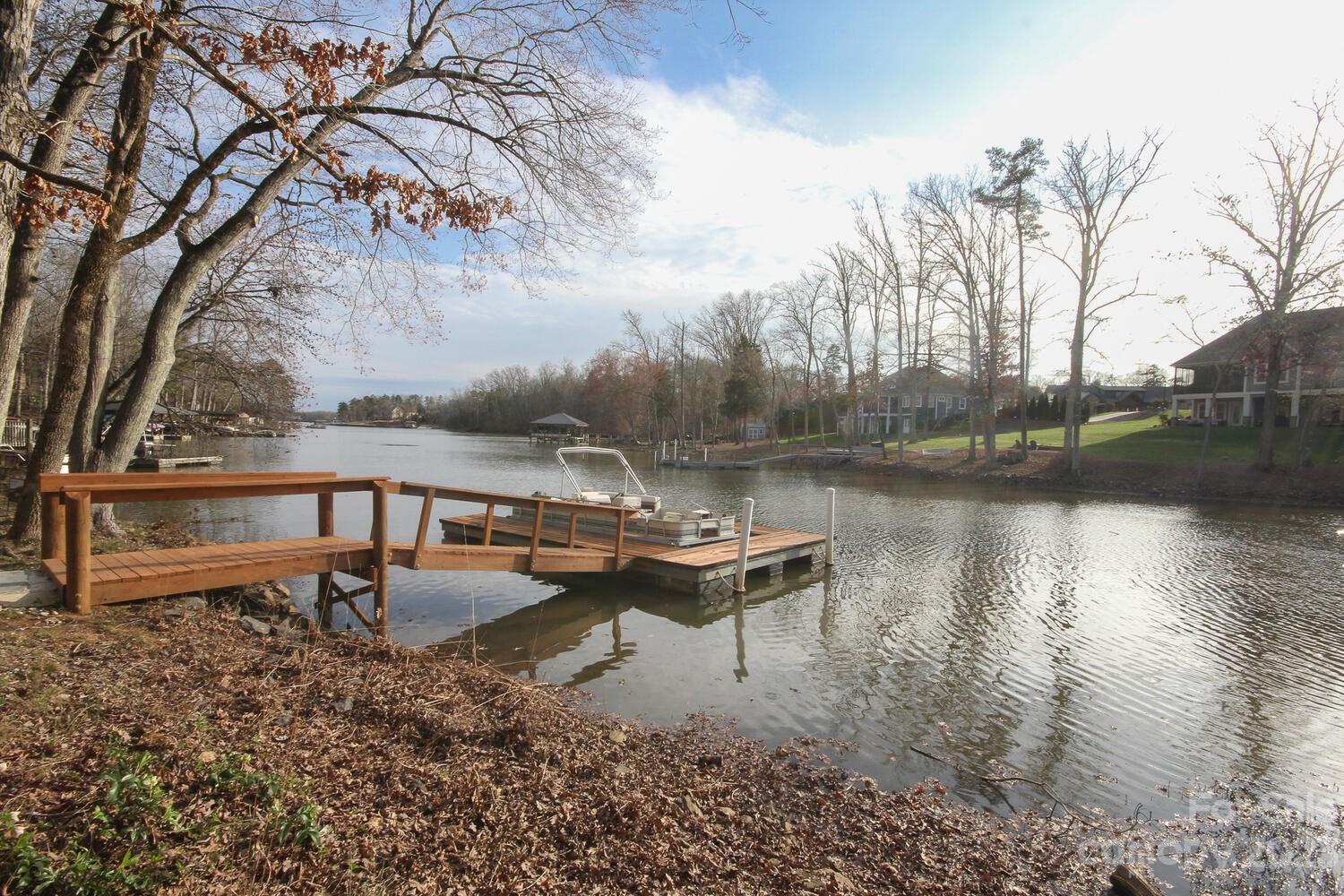 5615 Cypress Road Clover, SC 29710 - Photo 8 of 26 a view of a lake with chairs and wooden fence