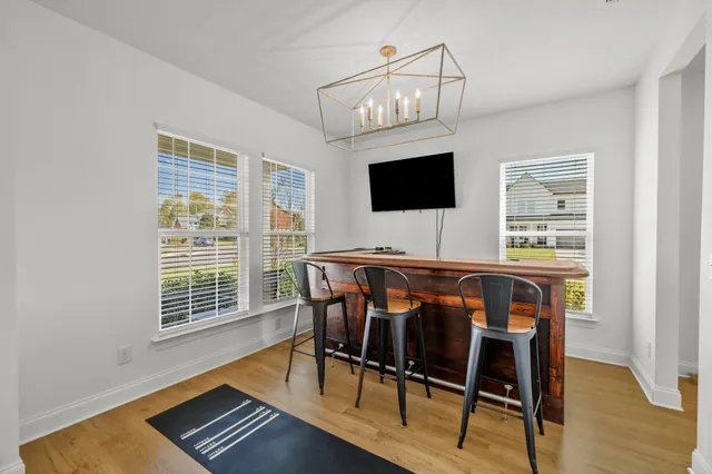 a view of a dining room with furniture a chandelier and wooden floor