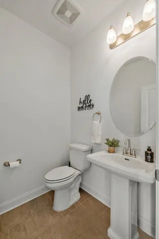 a bathroom with a sink mirror and toilet