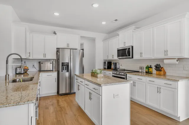 a kitchen with white cabinets and stainless steel appliances
