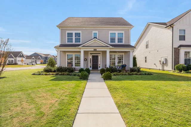 a front view of a house with yard and green space