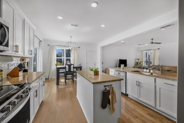 a kitchen that has a lot of cabinets a sink and appliances in it