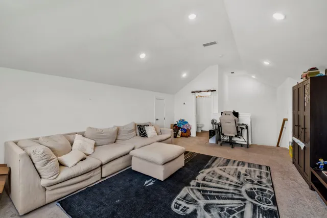 a living room with furniture a rug and a flat screen tv