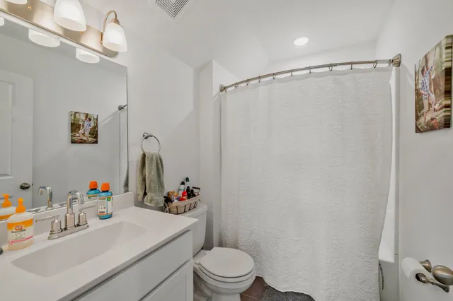 a bathroom with a sink vanity mirror and toilet