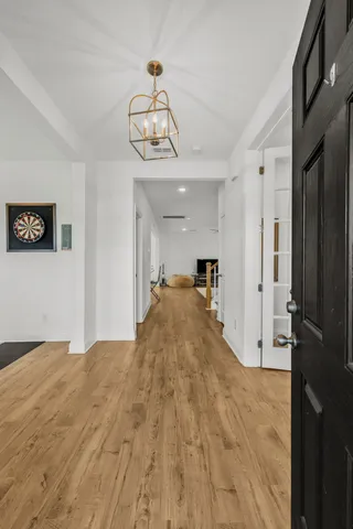 a view of a livingroom with wooden floor and a chandelier