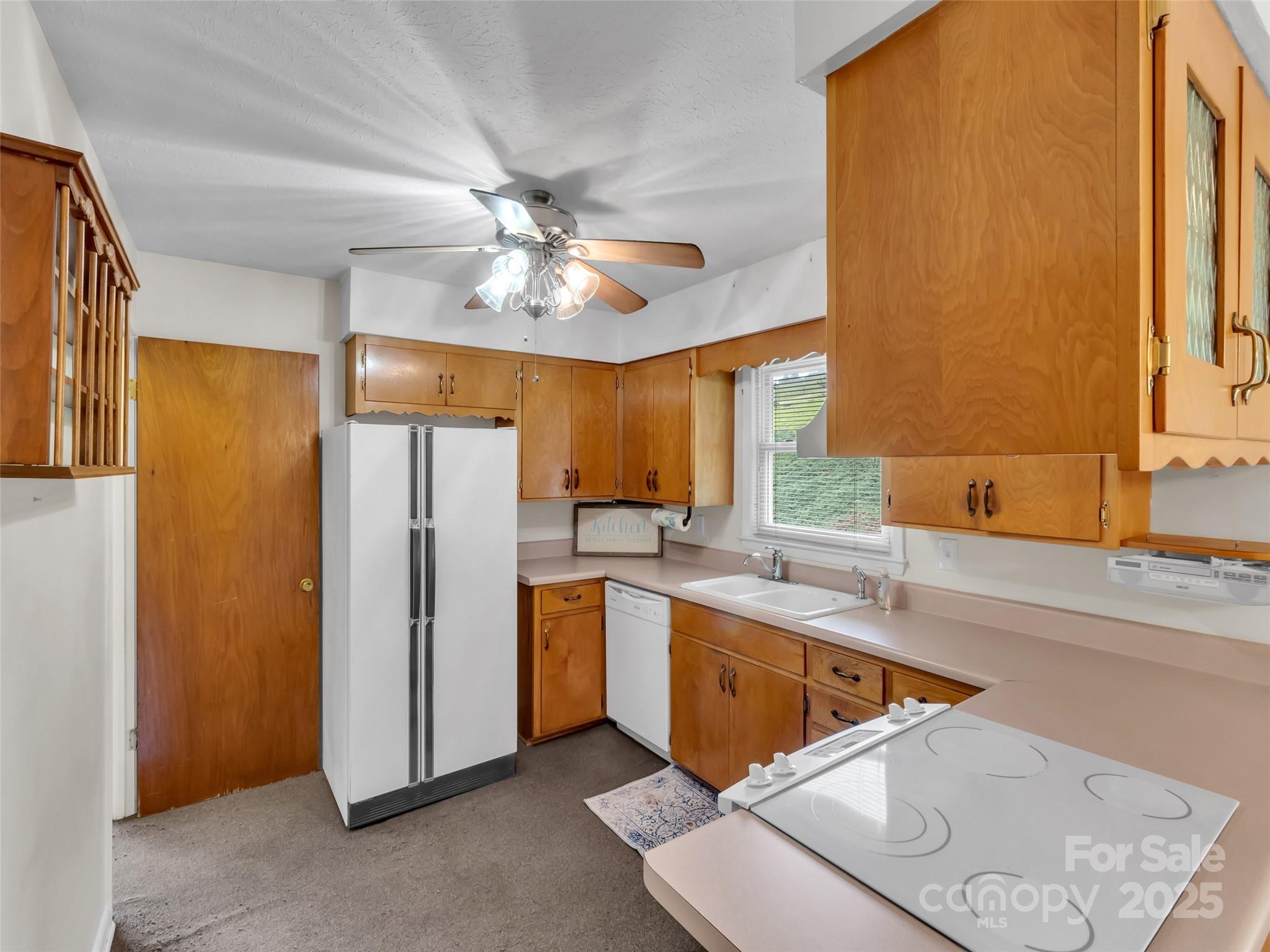250 Reeves Cove Road Candler, NC 28715 - Photo 7 of 47 a kitchen with a sink a refrigerator and cabinets