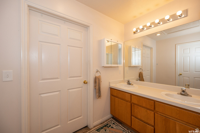 677 300 North, Unit 7 Provo, UT 84606 - Photo 8 of 16 Dual basin vanity with a laminate countertop, light wood-finish cabinetry, and a full-width mirror