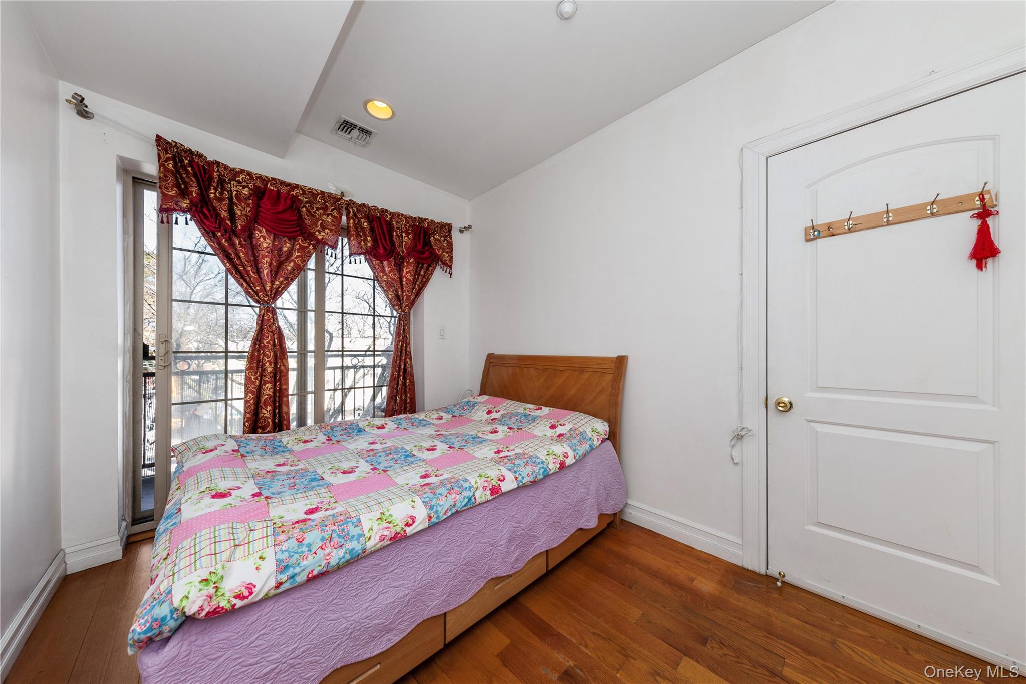 10716 37th Avenue, Unit 3B Queens, NY 11368 - Photo 12 of 19 a bedroom with a bed and a window