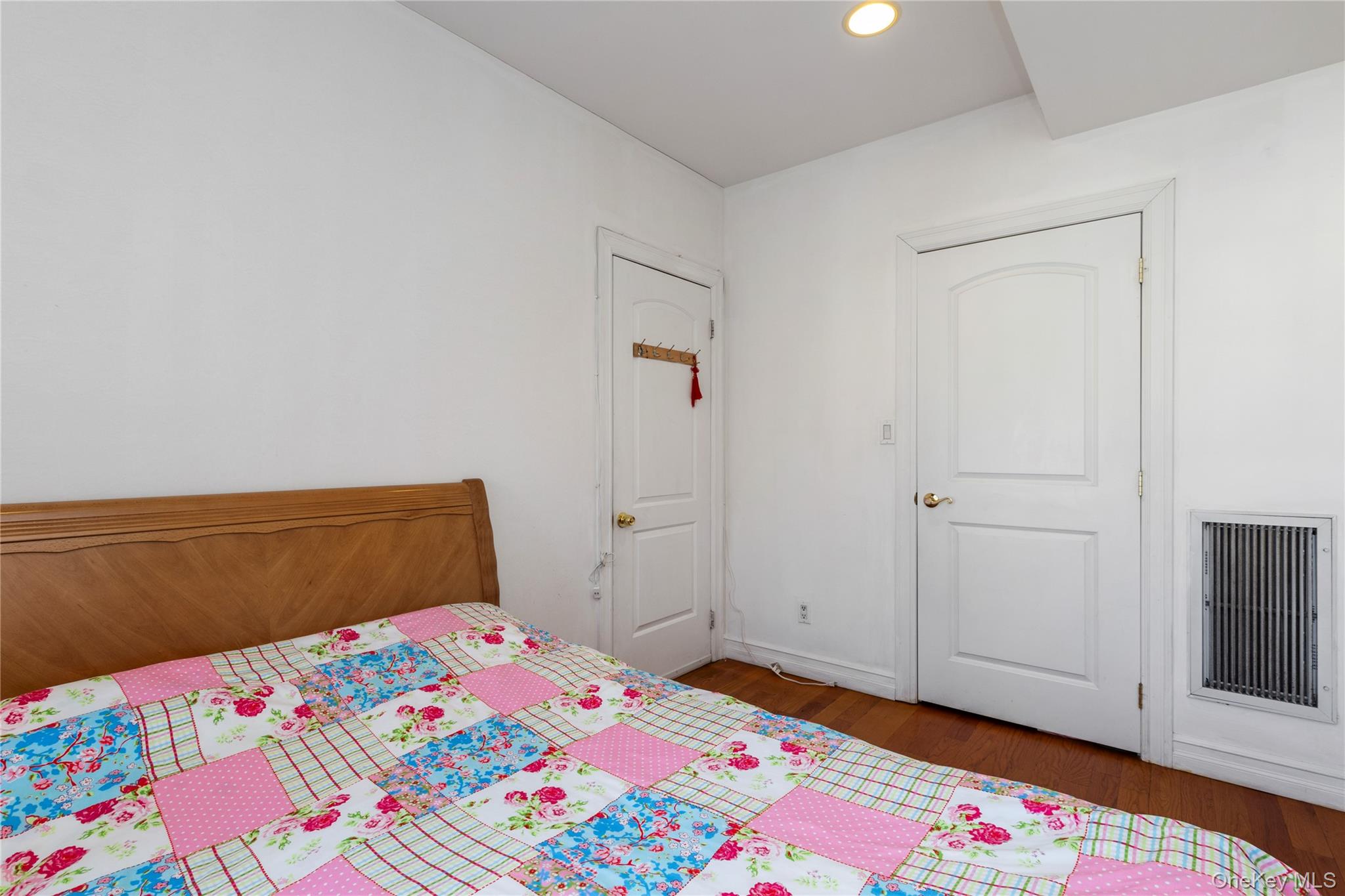 10716 37th Avenue, Unit 3B Queens, NY 11368 - Photo 14 of 19 a bedroom with a bed and wooden floor