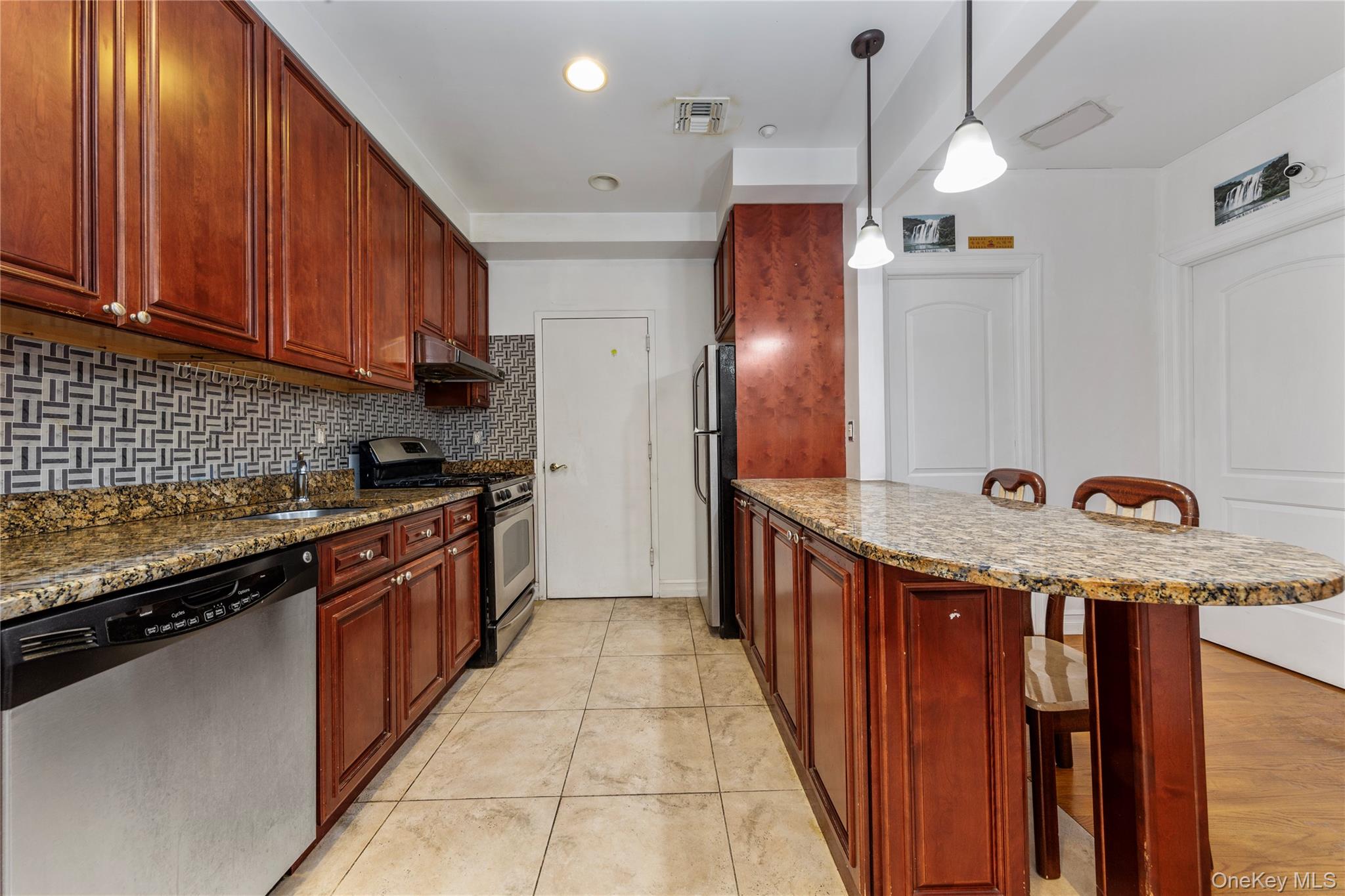 10716 37th Avenue, Unit 3B Queens, NY 11368 - Photo 3 of 19 a kitchen with stainless steel appliances granite countertop a stove a refrigerator and a sink