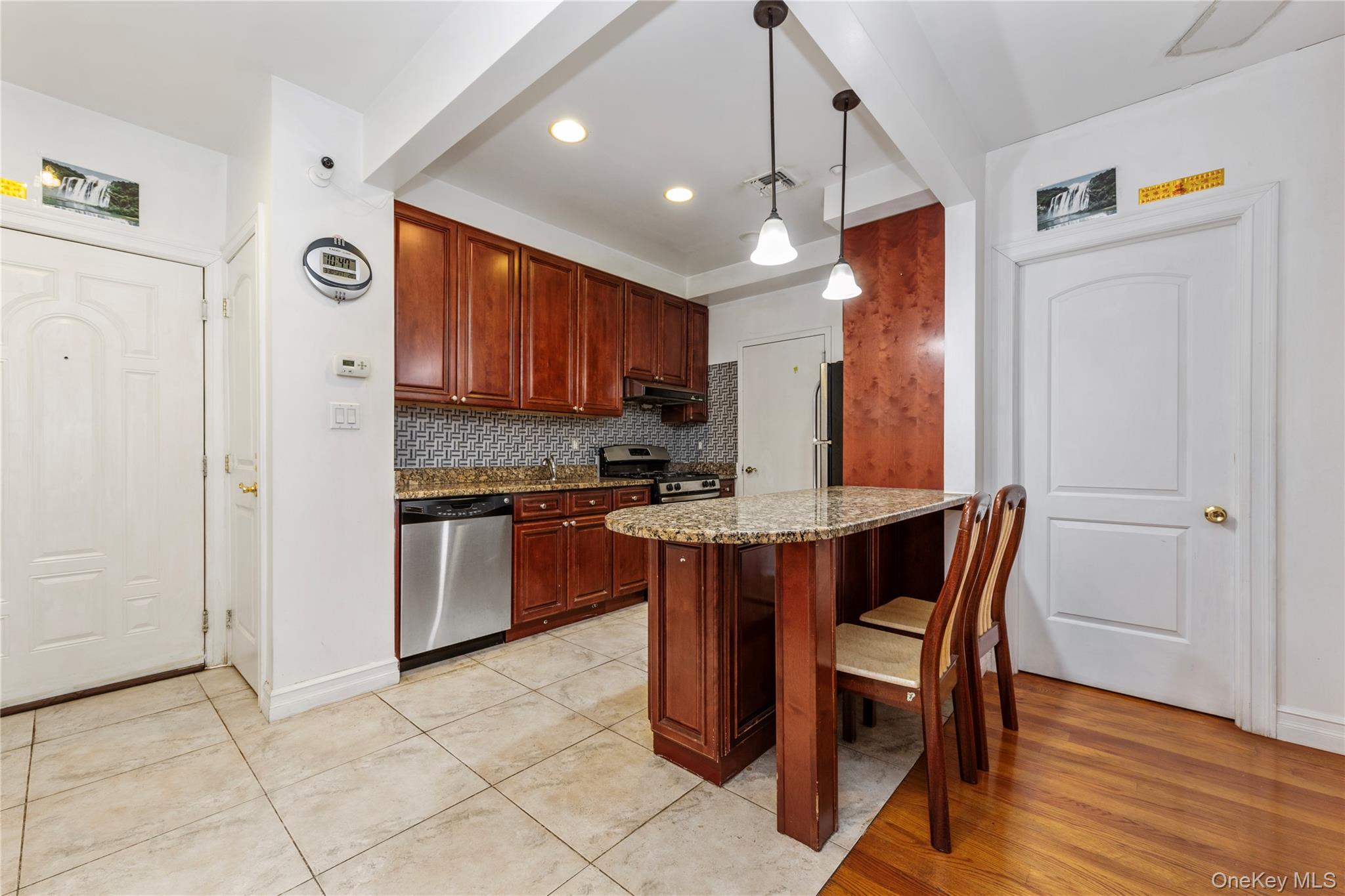 10716 37th Avenue, Unit 3B Queens, NY 11368 - Photo 4 of 19 a kitchen with stainless steel appliances granite countertop a stove top oven a refrigerator and a dinning table