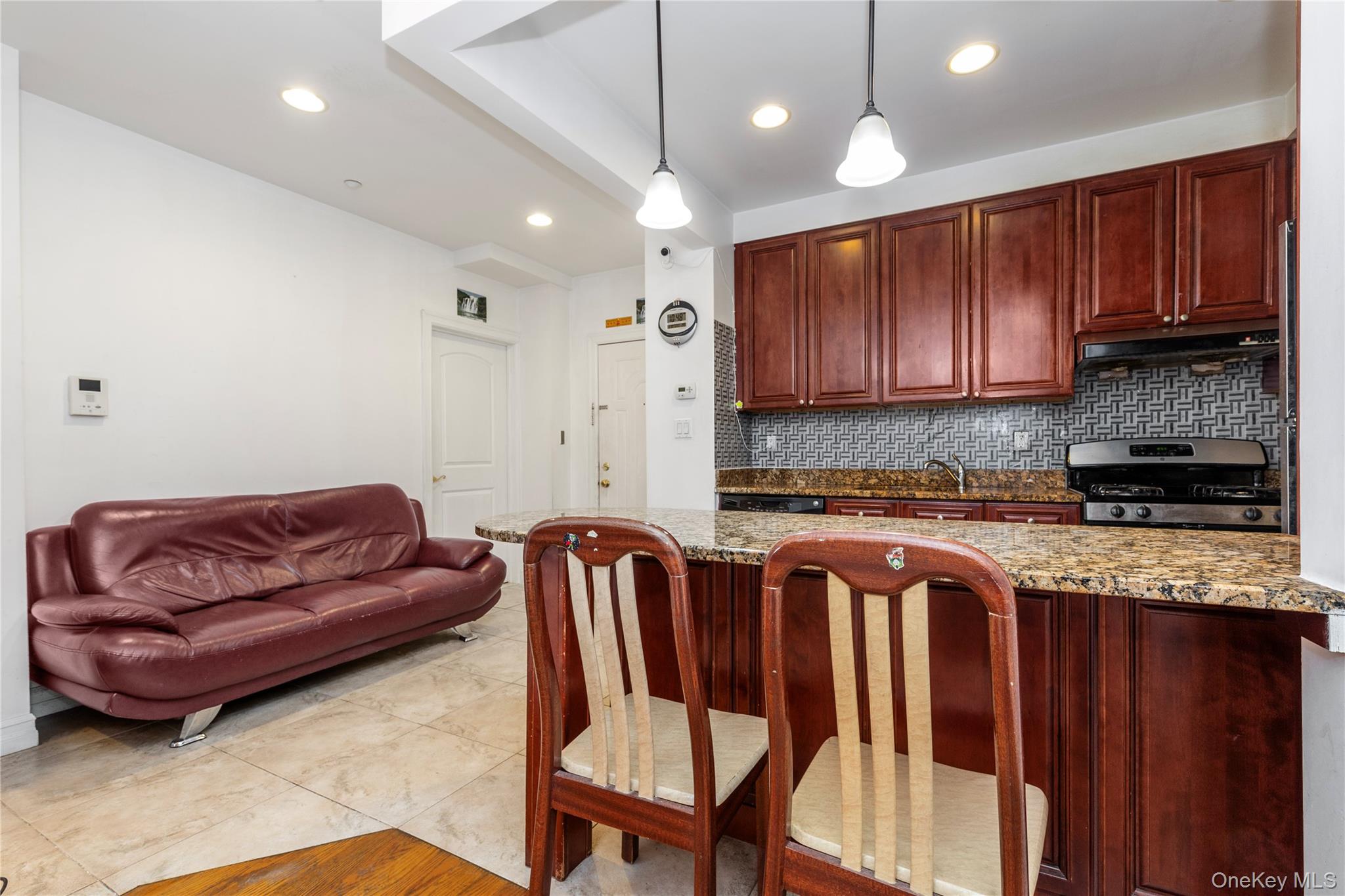 10716 37th Avenue, Unit 3B Queens, NY 11368 - Photo 5 of 19 a living room with furniture a wooden floor and a chandelier