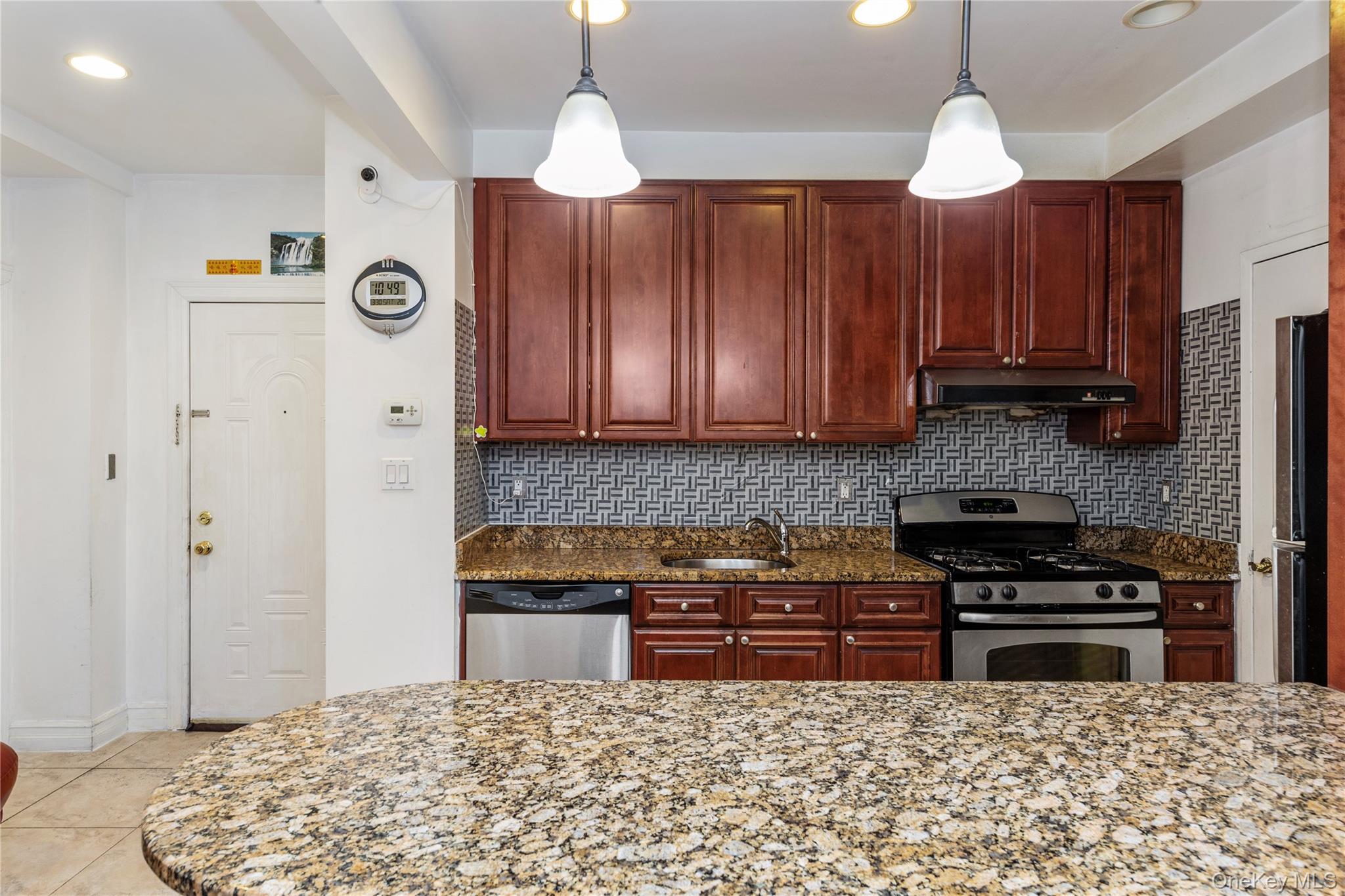 10716 37th Avenue, Unit 3B Queens, NY 11368 - Photo 7 of 19 a kitchen with granite countertop a stove a sink and a refrigerator