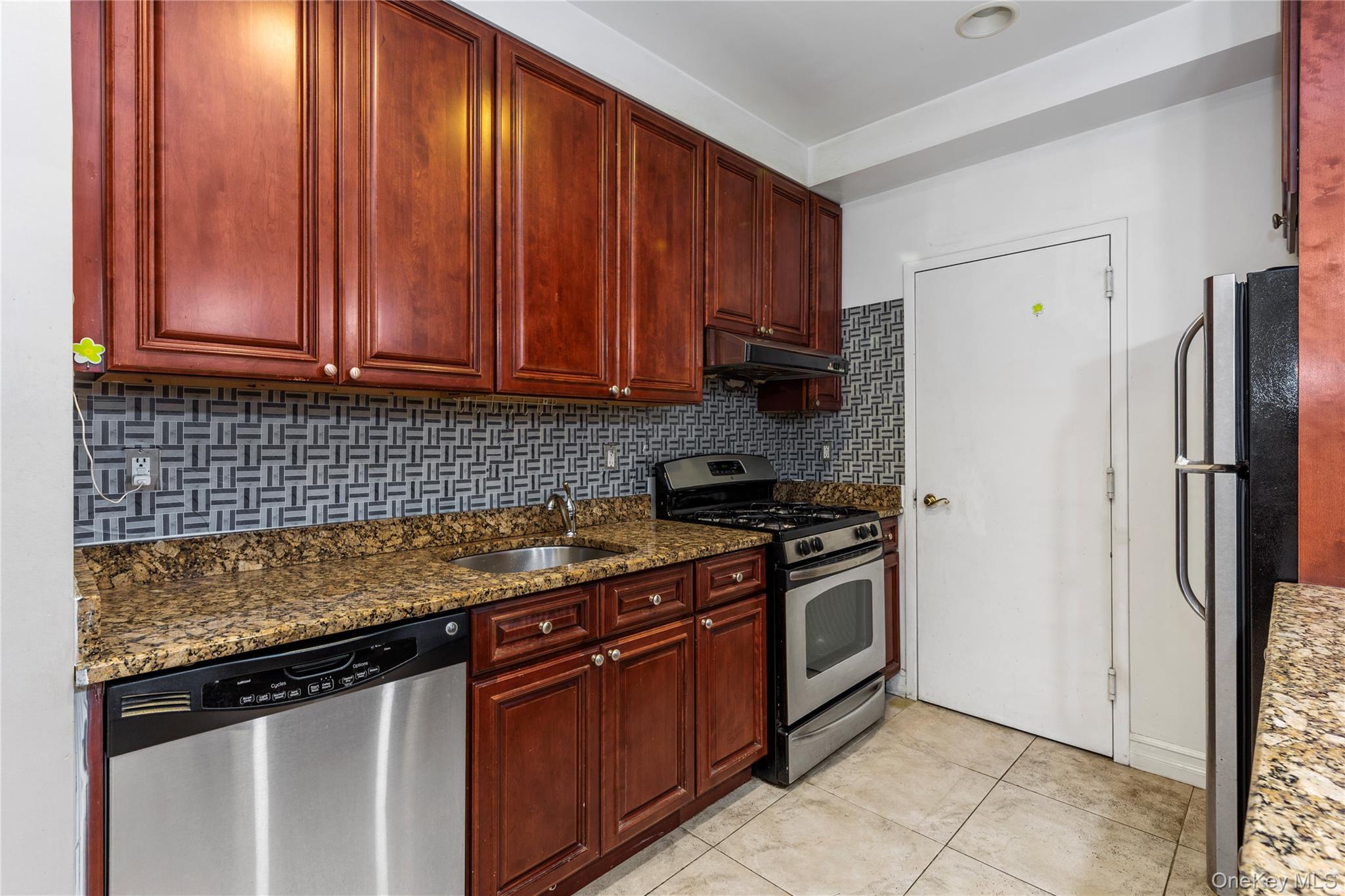 10716 37th Avenue, Unit 3B Queens, NY 11368 - Photo 8 of 19 a kitchen with stainless steel appliances granite countertop a stove a refrigerator and a sink