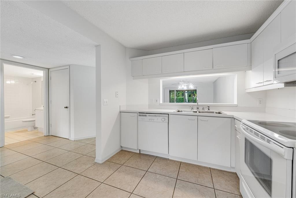 7761 Jewel Lane, Unit 103 Naples, FL 34109 - Photo 12 of 26 a kitchen with a sink cabinets and window