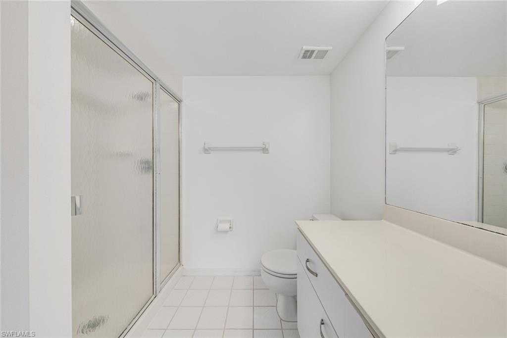 7761 Jewel Lane, Unit 103 Naples, FL 34109 - Photo 16 of 26 a bathroom with a granite countertop sink toilet and shower