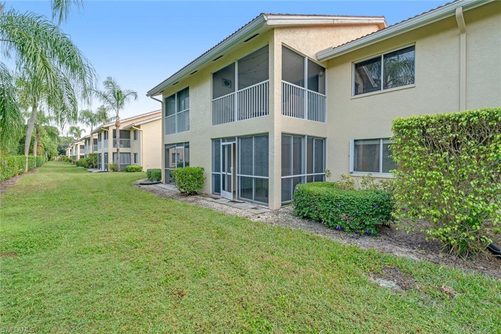 7761 Jewel Lane, Unit 103 Naples, FL 34109 - Photo 20 of 26 a front view of a house with a yard