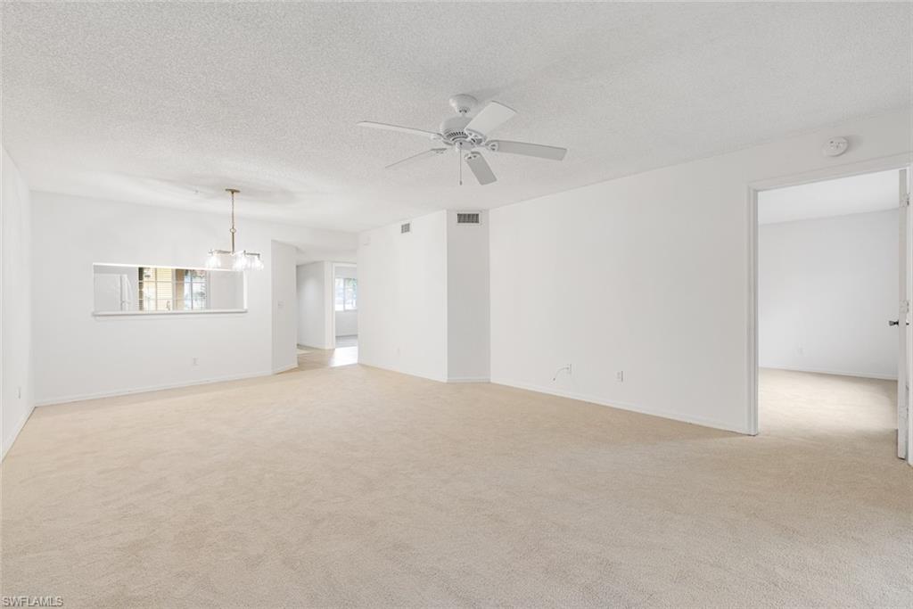 7761 Jewel Lane, Unit 103 Naples, FL 34109 - Photo 8 of 26 an empty room with windows and ceiling fan