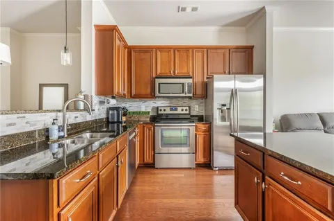 a kitchen with stainless steel appliances granite countertop a sink stove and refrigerator