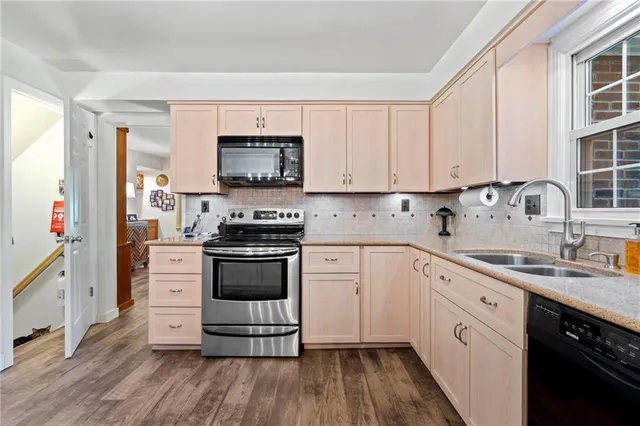 a kitchen with stainless steel appliances a white stove top oven and white cabinets