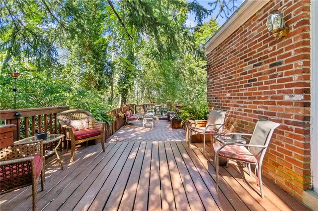 a view of a house with wooden deck and furniture