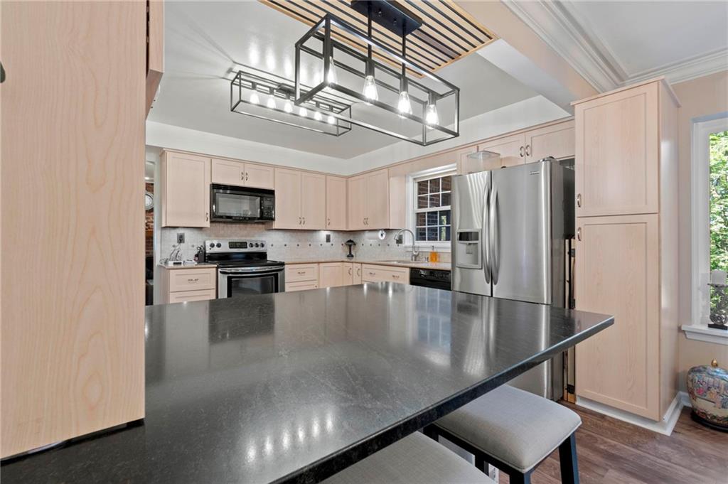 21 Oakglen Drive Oakmont, PA 15139 - Photo 10 of 50 a kitchen with stainless steel appliances granite countertop a refrigerator a stove a microwave oven a sink with a dining table and chairs