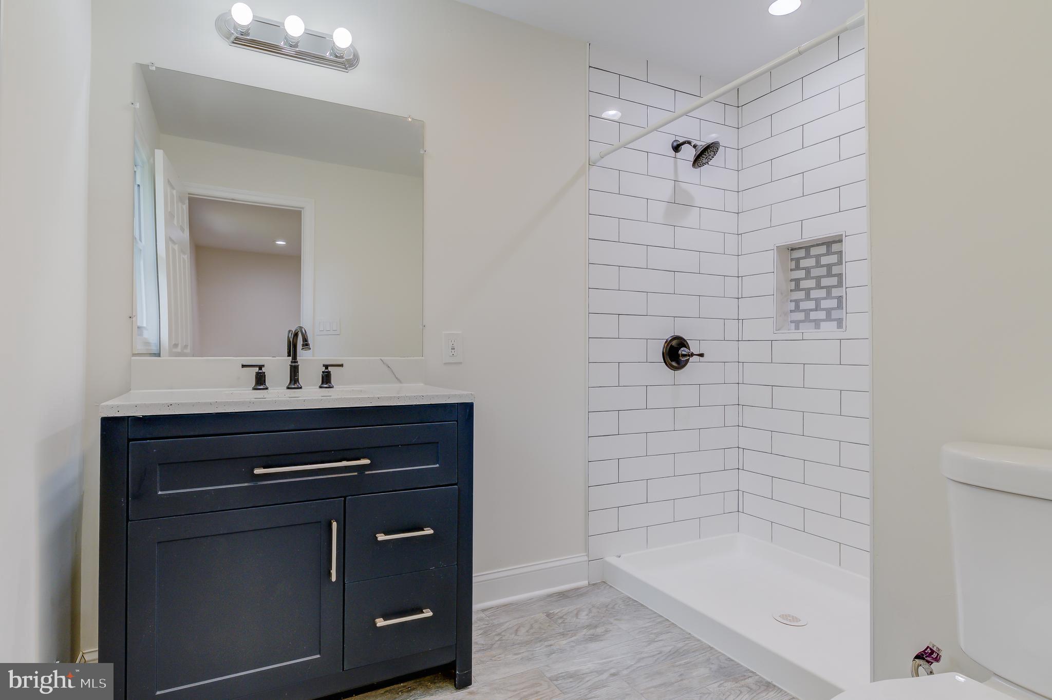 90 Princeton Hightstown Road Princeton Junction, NJ 08550 - Photo 13 of 20 a bathroom with a sink a mirror and shower
