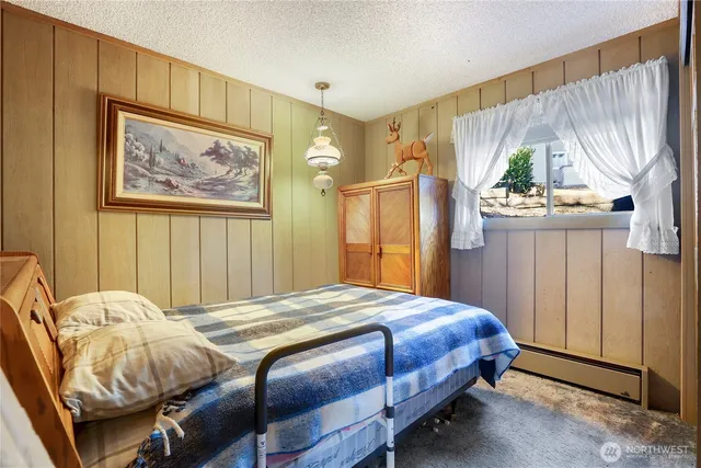 a bedroom with a bed and a painting on the wall