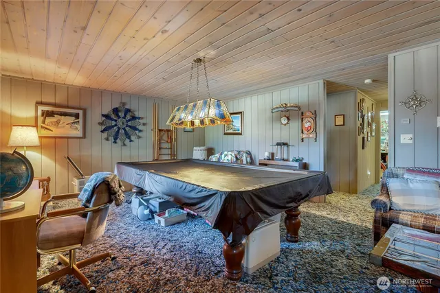 a room with furniture pool table and window